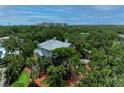 Aerial view of estate with lush tropical landscaping and large pool at 8963 Fishermens Bay Dr, Sarasota, FL 34231