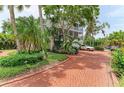 Three story home surrounded by lush tropical landscaping, circular driveway, and multiple balconies at 8963 Fishermens Bay Dr, Sarasota, FL 34231