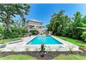 Inviting backyard featuring a refreshing pool, lounging area, and a picturesque view of the home at 8963 Fishermens Bay Dr, Sarasota, FL 34231