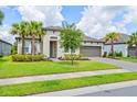 Beautiful home with a well-maintained lawn and landscaping, and a brick paver driveway leading to a two-car garage at 926 Fernleaf Run, Bradenton, FL 34212