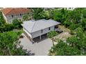 Gorgeous home with a metal roof, wooden garage doors and an exterior staircase, surrounded by lush greenery at 105 Shore Rd, Nokomis, FL 34275