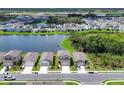 A serene aerial view of a lakeside community with well-maintained homes and green spaces at 10611 Ladybug Cv, Parrish, FL 34219