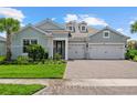 Attractive home with a lush green lawn, brick driveway, and a convenient two-car garage at 12139 Cranston Way, Bradenton, FL 34211