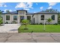 A modern home with a paver driveway and lush landscaping at 1605 Landfall Dr, Nokomis, FL 34275