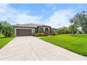 A long, paved driveway leads to a home with a two-car garage and colorful landscaping at 1711 145Th E St, Sarasota, FL 34212