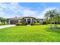 Home features a well-manicured lawn, palm trees, and a welcoming blue double-door entry at 1711 145Th E St, Sarasota, FL 34212