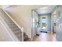 Inviting foyer with tile flooring, stairway, and a glass-paneled door to let in natural light at 17904 Tavernside Trl, Bradenton, FL 34211