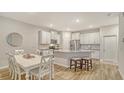 Beautiful kitchen with white cabinetry, granite countertops, stainless steel appliances, and a dining area at 18324 Cropside Trl, Lakewood Ranch, FL 34211
