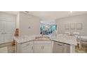 Modern kitchen island with granite countertop and stainless steel dishwasher with view to living room at 18324 Cropside Trl, Lakewood Ranch, FL 34211