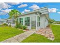 Bright sunroom with large windows, tile accents, and a cozy spot for relaxing and enjoying the view at 202 Bedford Trl # 120, Sun City Center, FL 33573