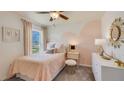 Bright bedroom with soft pink accents, decorative wall painting, comfy bed, and view to the outside at 3278 Rock Sound St, Bradenton, FL 34208