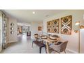 Open-concept dining area with modern table, chairs, bench, decorative wall art, and seamless flow into the living room at 3278 Rock Sound St, Bradenton, FL 34208