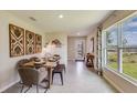 Dining room with table, chairs, and bench, decorative wood art, and a large window with natural light at 3278 Rock Sound St, Bradenton, FL 34208