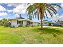Single-story home with white exterior, a front yard, and a driveway leading to an attached garage at 3303 Cambridge W Dr, Bradenton, FL 34205