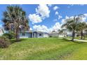 Charming single-story home with a well-manicured lawn and beautiful palm trees against a blue sky at 3339 Duar Ter, North Port, FL 34291