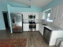 Modern kitchen featuring stainless steel appliances, white cabinets, and tile backsplash at 3339 Duar Ter, North Port, FL 34291