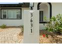 Close up of house numbers on a post surrounded by landscaping at this cozy, modern home at 3631 Palm Dr, Punta Gorda, FL 33950