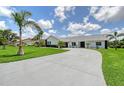 Beautiful one-story home with a paved driveway, black and white exterior paint and landscaping at 3634 Torrey Pines Way Way, Sarasota, FL 34238
