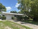 Inviting single-story home with a well-manicured lawn, attached garage and long driveway under a shady tree at 4149 Prudence Dr, Sarasota, FL 34235