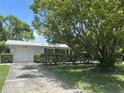 Inviting single-story home with a well-manicured lawn, attached garage and long driveway under a shady tree at 4149 Prudence Dr, Sarasota, FL 34235