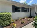 Exterior view of home with well-maintained landscaping and decorative shutters, creating a welcoming entrance at 4149 Prudence Dr, Sarasota, FL 34235