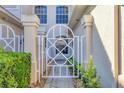 Close up view of the private gated entrance with brick paver walkway and manicured landscaping at 4487 Cinnamon Dr # 2604, Sarasota, FL 34238