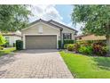 Charming single-story home with a well-kept lawn and a paved driveway leading to the garage at 5117 Serata Dr, Bradenton, FL 34211