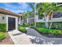 Charming condo exterior showcases tropical landscaping and a private entrance at 5695 Palmer Cir # 203, Bradenton, FL 34211