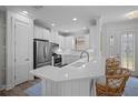 Bright kitchen featuring white cabinets, stainless steel appliances, and a breakfast bar with seating at 5866 Cavano Dr, Sarasota, FL 34231