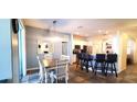 Bright dining area with modern lighting, tile floors, and an open layout connecting to the kitchen at 6107 French Creek Ct, Ellenton, FL 34222