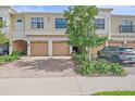 Townhome exteriors featuring two car garages with brick driveways and manicured landscaping at 7325 Skybird Rd # 399, Bradenton, FL 34209