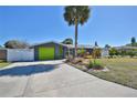 Charming home featuring a bright, lime-green garage door, landscaped garden, and a spacious driveway at 7355 Cass Cir, Sarasota, FL 34231