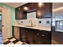 Well-equipped kitchen with dark wood cabinets, stainless steel appliances, and eye-catching black and white flooring at 7355 Cass Cir, Sarasota, FL 34231