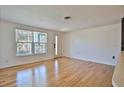 Bright living room with hardwood floors, a large window, and a white door at 7355 Cass Cir, Sarasota, FL 34231