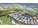 Aerial view of a home circled in blue, overlooking a lush golf course and a serene lake at 7542 Windy Hill Cv, Bradenton, FL 34202