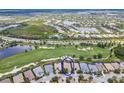 Aerial view of a home circled in blue, situated on a well-manicured property near a golf course and lakes at 7542 Windy Hill Cv, Bradenton, FL 34202