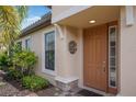 The front door offers curb appeal, featuring a sidelight, a decorative wreath, and manicured landscaping at 8291 Varenna Dr, Sarasota, FL 34231