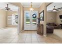 Inviting foyer with neutral tile flooring, transom windows, and a decorative console table at 866 Oak Briar Ln, Osprey, FL 34229