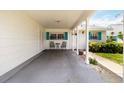 Welcoming front porch with seating area, teal shutters, and a neutral color scheme creating curb appeal at 9412 Concord Cir, Bradenton, FL 34210