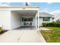 Inviting home exterior with a covered carport, vibrant teal shutters and well maintained front yard at 9412 Concord Cir, Bradenton, FL 34210
