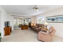 Cozy living room featuring comfortable seating, neutral carpet, and sliding glass doors leading to sunroom at 9412 Concord Cir, Bradenton, FL 34210