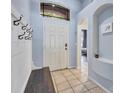 Bright foyer featuring tile floors, coat hooks, and natural light from a transom window at 1126 Barclay Wood Dr, Ruskin, FL 33570