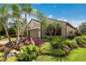 Beautiful exterior with lush tropical landscaping surrounding the home and a paver driveway at 13338 Torresina Ter, Lakewood Ranch, FL 34211