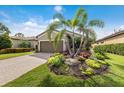 Charming exterior with lush landscaping, palm trees and a paver driveway leading to the garage at 13338 Torresina Ter, Lakewood Ranch, FL 34211