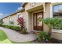 Inviting front entrance featuring a lovely brown double door, brick walkway, and well-maintained landscaping at 13338 Torresina Ter, Lakewood Ranch, FL 34211