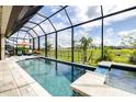 Resort-style pool with screened-in enclosure and a breathtaking view of the lush green backyard at 13871 Heartwood Way, Parrish, FL 34219