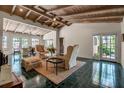 Spacious living room with vaulted wood beam ceiling, accent chairs, a fireplace, and glass doors to the outside at 1808 Coquina Dr, Sarasota, FL 34231