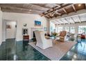 Inviting living room featuring a vaulted ceiling, a cozy fireplace, neutral decor, and eye-catching green tile floors at 1808 Coquina Dr, Sarasota, FL 34231