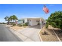 Inviting one-story home with a carport, featuring an American flag and manicured landscaping at 2107 Palma Sola Blvd # 7, Bradenton, FL 34209