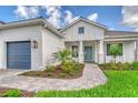 Charming home with a beautifully landscaped yard and a welcoming front entrance with a teal-colored front door at 2469 Paradise Plum Dr, Sarasota, FL 34240